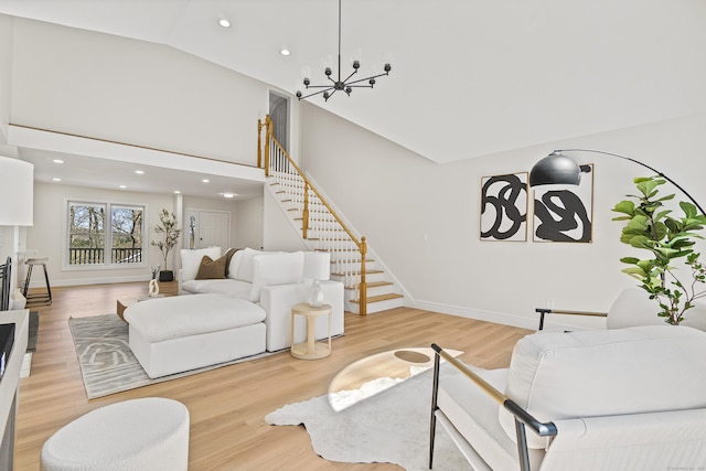 living area with light wood-style floors, recessed lighting, a notable chandelier, and stairs