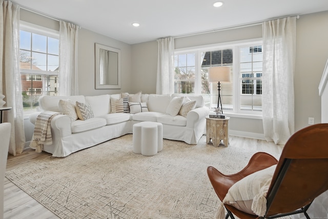 living area with a wealth of natural light, recessed lighting, wood finished floors, and baseboards