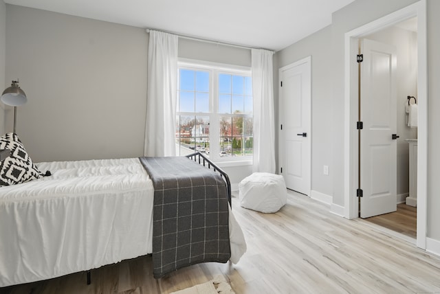 bedroom with baseboards and wood finished floors