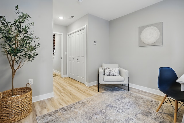 sitting room with visible vents, baseboards, and wood finished floors