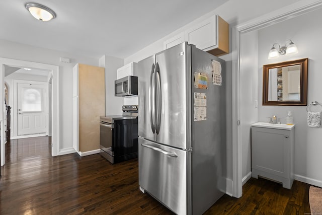 4 Glynn Ave, Middletown, CT 06457 - kitchen with appliances with stainless steel finishes, dark wood-type flooring, white cabinetry, and baseboards