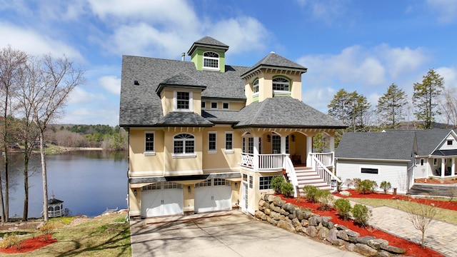 72 Indian Spring Rd, Woodstock, CT 06281 - view of front of property featuring driveway, a water view, a shingled roof, stucco siding, and a porch
