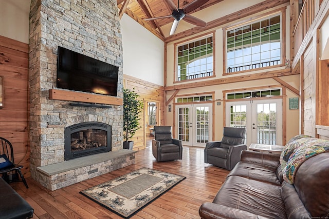 72 Indian Spring Rd, Woodstock, CT 06281 - living room featuring ceiling fan, hardwood / wood-style floors, a towering ceiling, french doors, and a stone fireplace