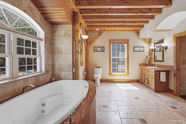 72 Indian Spring Rd, Woodstock, CT 06281 - full bath featuring a tub with jets, stone tile floors, a wealth of natural light, and baseboards