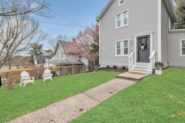 view of front of house featuring entry steps and a front yard