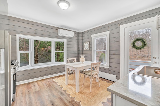 dining space featuring wooden walls, a wall mounted air conditioner, light wood-type flooring, and ornamental molding