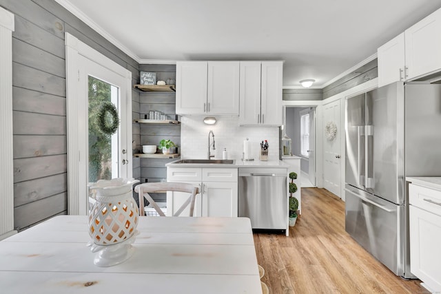 kitchen featuring open shelves, a wealth of natural light, stainless steel appliances, and a sink