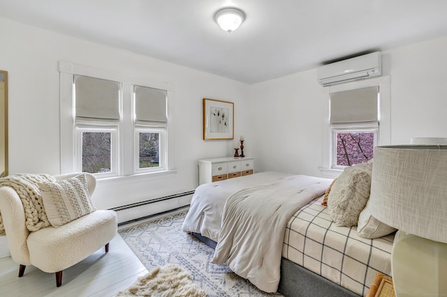 bedroom with baseboard heating, wood finished floors, and a wall mounted AC