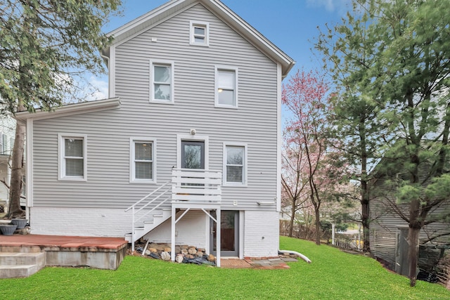 rear view of house featuring a wooden deck, a lawn, and stairway