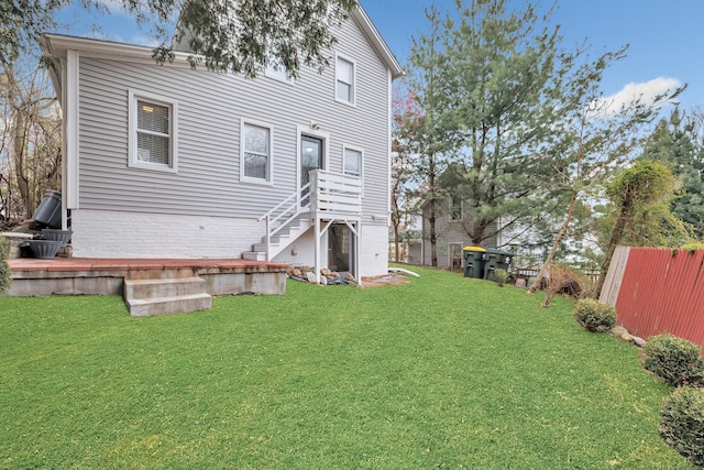 back of property with a lawn and fence
