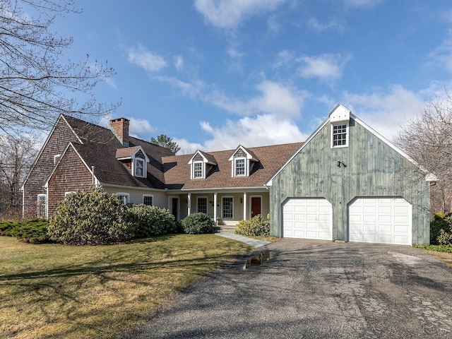 view of front of house featuring aphalt driveway, roof with shingles, a front lawn, a chimney, and a garage