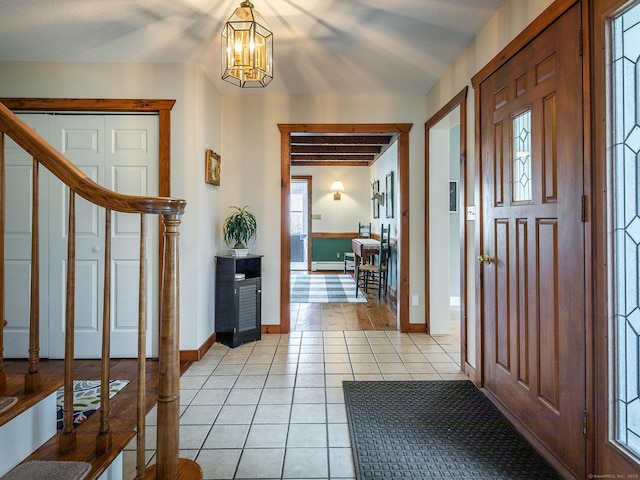 entrance foyer with stairs, light tile patterned floors, a notable chandelier, and a healthy amount of sunlight