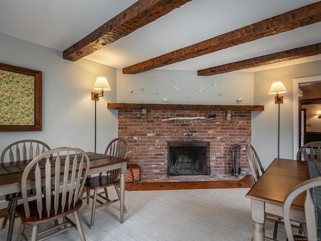 dining space featuring beamed ceiling and a fireplace