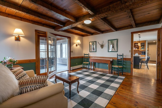 living area featuring wood-type flooring, wood ceiling, a wainscoted wall, and beam ceiling