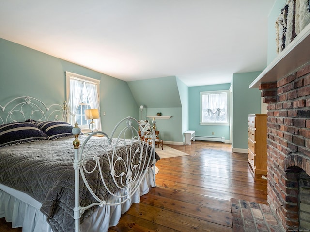 bedroom with a baseboard radiator, baseboards, lofted ceiling, and hardwood / wood-style flooring