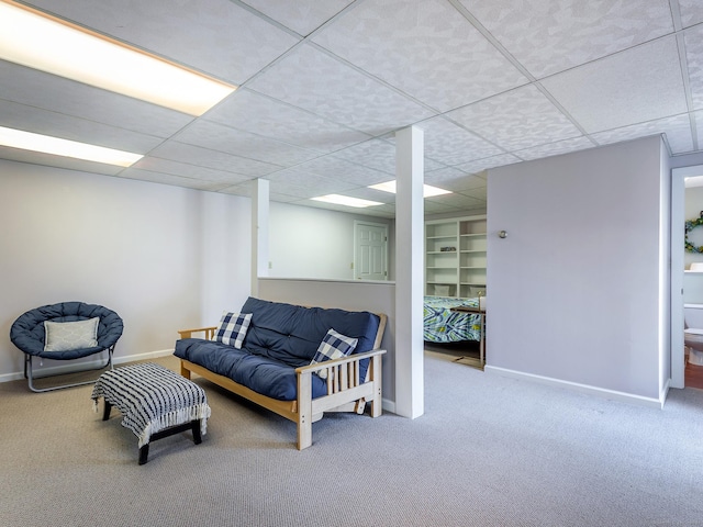 carpeted living room featuring a paneled ceiling and baseboards