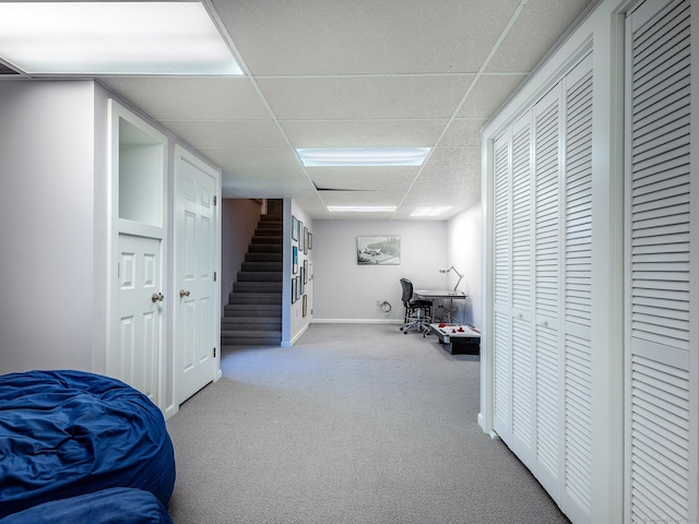 carpeted bedroom featuring a paneled ceiling and baseboards