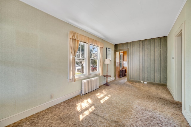 unfurnished bedroom with baseboards, radiator, and carpet