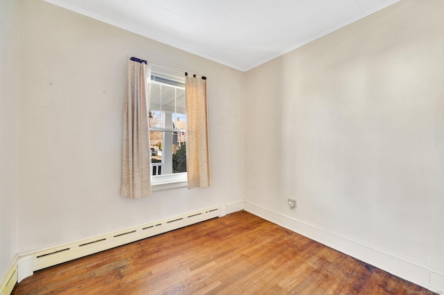 unfurnished room with baseboard heating, hardwood / wood-style floors, baseboards, and ornamental molding