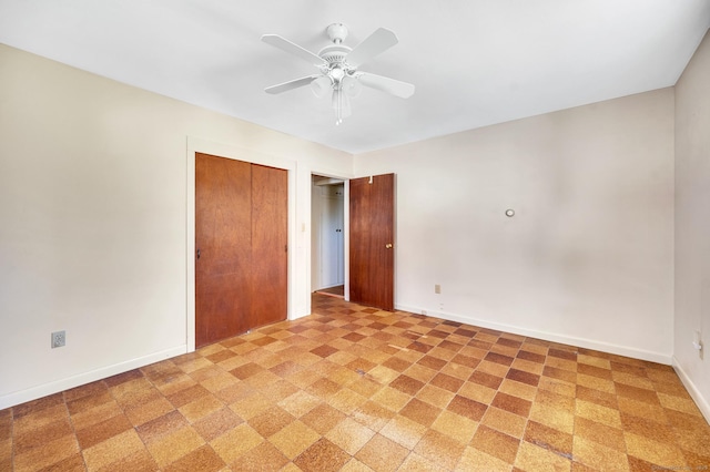 unfurnished room featuring ceiling fan and baseboards