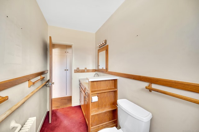 bathroom with toilet, radiator, and vanity