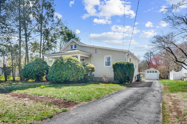 view of side of property featuring an outbuilding, a garage, a yard, and driveway