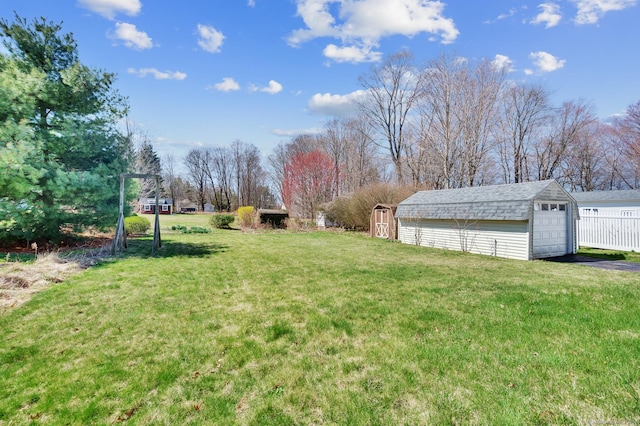 view of yard featuring an outbuilding, a garage, and driveway