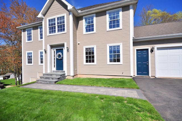 view of front of house featuring driveway and a front lawn