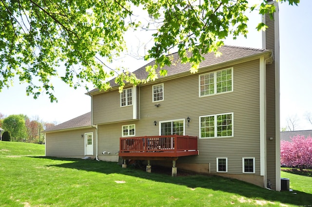 rear view of house featuring a lawn, a wooden deck, central AC unit, and a chimney