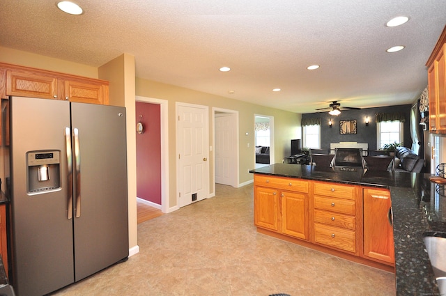 kitchen with stainless steel refrigerator with ice dispenser, ceiling fan, recessed lighting, and a peninsula