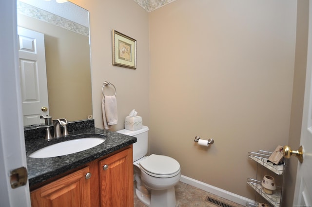 bathroom with visible vents, vanity, baseboards, tile patterned floors, and toilet