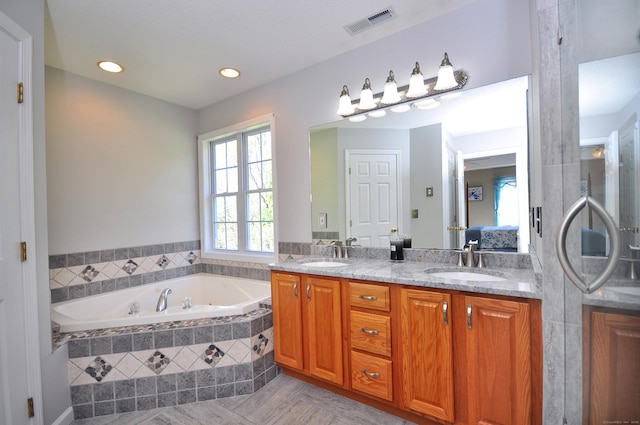 ensuite bathroom with a sink, a garden tub, double vanity, and connected bathroom