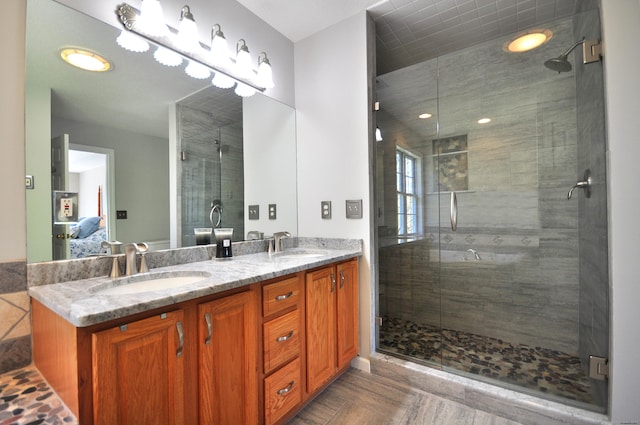 full bathroom with double vanity, a sink, ensuite bath, and a stall shower