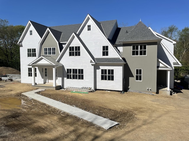 view of front of property with a porch and roof with shingles