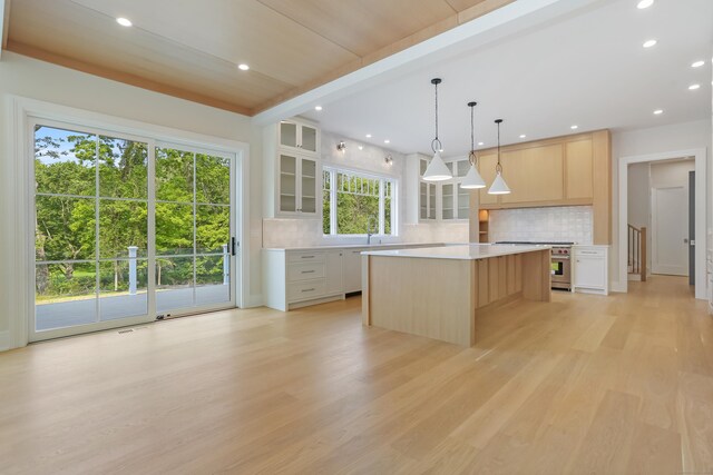 11 Tierney Ln, Westport, CT 06880 - kitchen featuring high end stainless steel range oven, light countertops, glass insert cabinets, a center island, and backsplash
