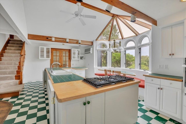 89 E St, Morris, CT 06763 - kitchen featuring stainless steel gas cooktop, a sink, white cabinets, wood counters, and light flooring