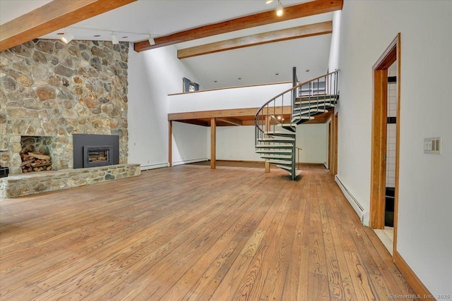 89 E St, Morris, CT 06763 - unfurnished living room with a baseboard radiator, wood-type flooring, stairway, a fireplace, and rail lighting