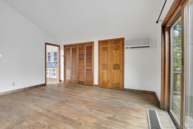 89 E St, Morris, CT 06763 - unfurnished bedroom featuring a wall mounted AC, light wood-type flooring, baseboards, and vaulted ceiling