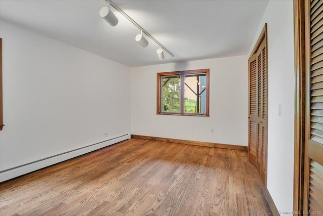 89 E St, Morris, CT 06763 - unfurnished bedroom with a baseboard heating unit, wood finished floors, baseboards, rail lighting, and a closet