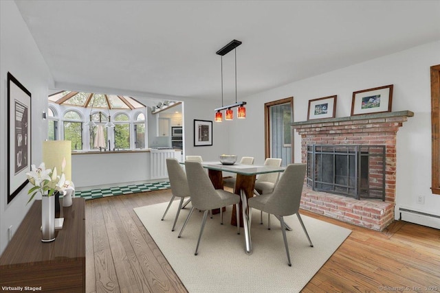 89 E St, Morris, CT 06763 - dining area with wood-type flooring, a brick fireplace, and a baseboard radiator