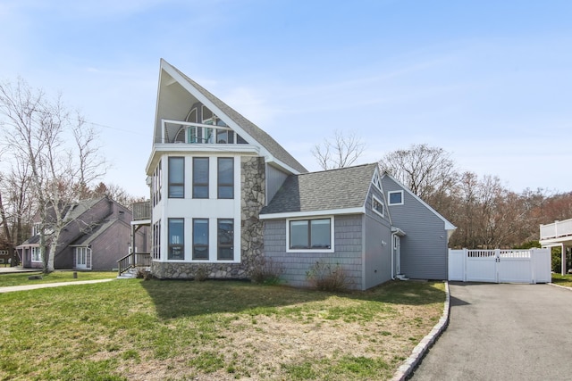 75 N Main St, East Hampton, CT 06424 - view of front of home with a gate, roof with shingles, stone siding, driveway, and a balcony