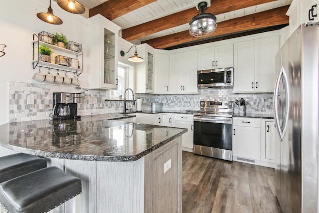 75 N Main St, East Hampton, CT 06424 - kitchen with appliances with stainless steel finishes, a peninsula, dark wood finished floors, tasteful backsplash, and glass insert cabinets