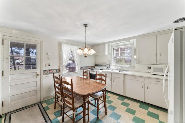 dining room with a notable chandelier and light floors