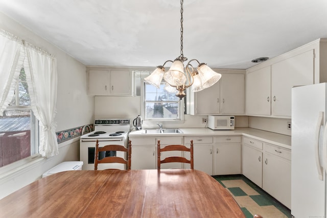 kitchen featuring butcher block countertops, an inviting chandelier, white appliances, visible vents, and a sink