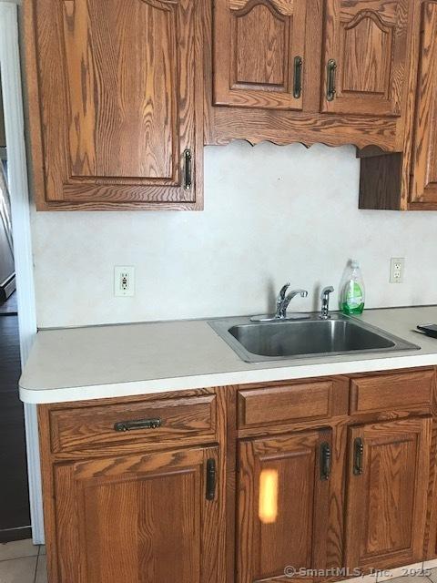14 Court St, West Haven, CT 06516 - kitchen featuring brown cabinetry, light countertops, and a sink