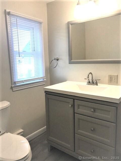 14 Court St, West Haven, CT 06516 - half bathroom with vanity, baseboards, toilet, and wood finished floors