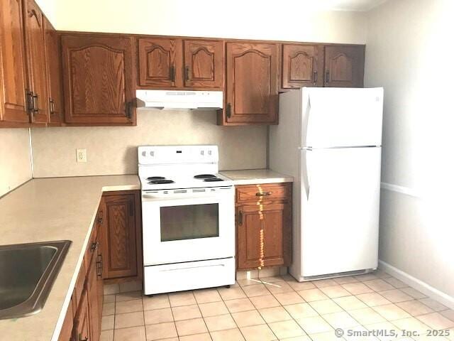 14 Court St, West Haven, CT 06516 - kitchen featuring brown cabinets, light countertops, white appliances, and under cabinet range hood