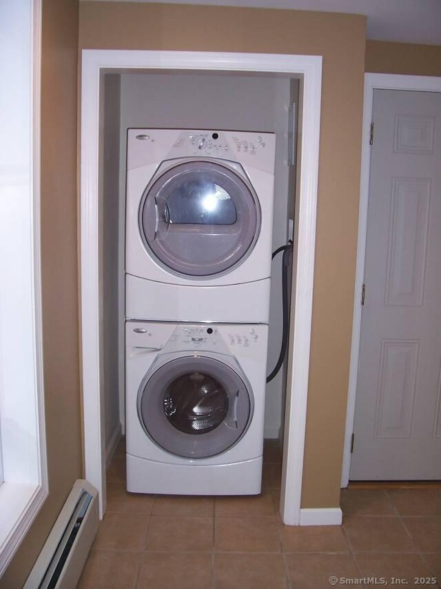 14 Court St, West Haven, CT 06516 - laundry room with tile patterned floors, a baseboard radiator, stacked washing maching and dryer, and laundry area