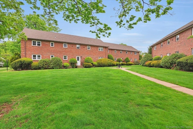 view of green lawn with entry steps