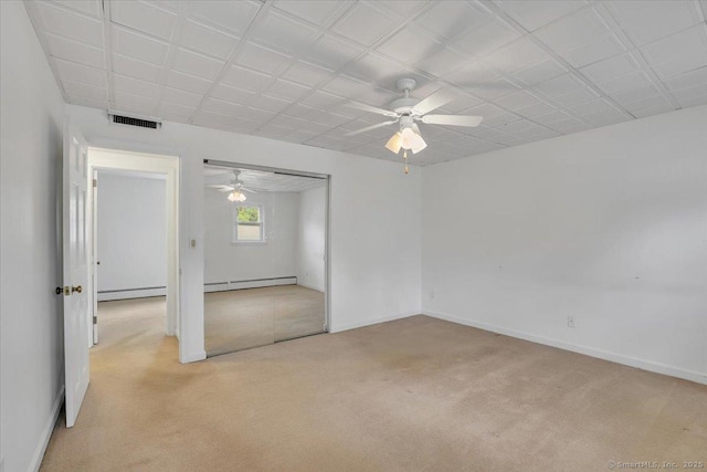 empty room with a baseboard radiator, ceiling fan, and light carpet